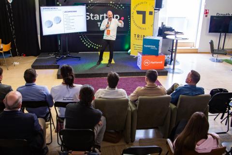 Henkilö lavalla pitchaamassa omaa startup -yritystään tuomaristolle.