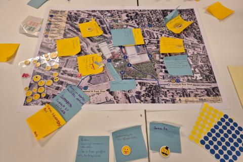 Post-it-lappuja ja tarroja Hakametsä Sport Campusta esittävän kartan päällä.