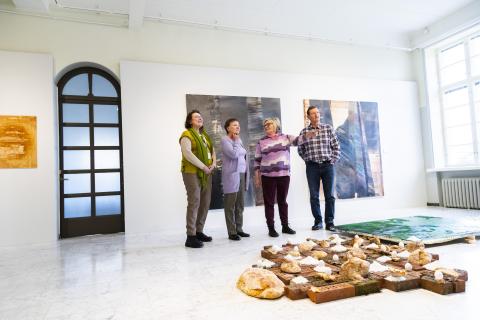 Neljä kulttuuriluotsia on valoisassa galleriassa katselemassa taidetta.