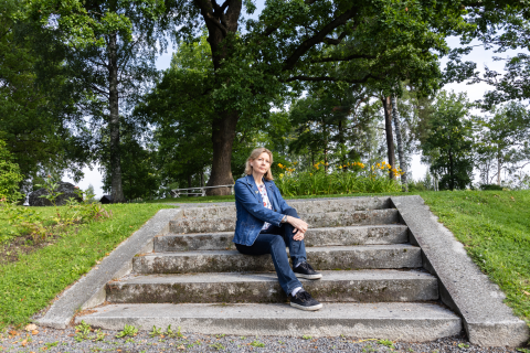 A person is sitting on an old staircase in the middle of the park.