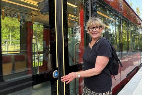 Hanna Kesonen on nousemassa ratikkaan ja hymyilee kameralle.