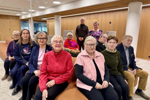 The members of the Tampere Older People's Council are sitting on the sofa, looking towards the camera.